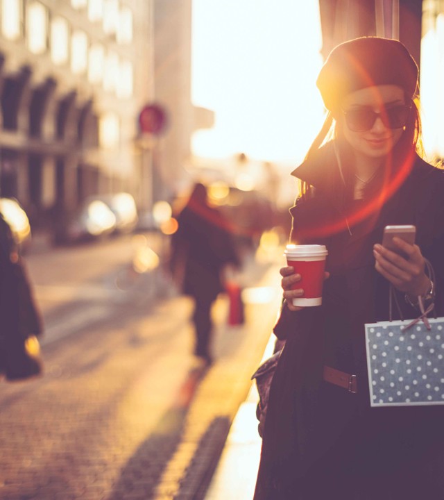 A shopper walking through a city street at golden hour